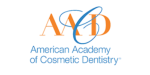 Logo of the American Academy of Cosmetic Dentistry. Orange "AACD" with a blue swoosh intertwined. Text below reads "American Academy of Cosmetic Dentistry."